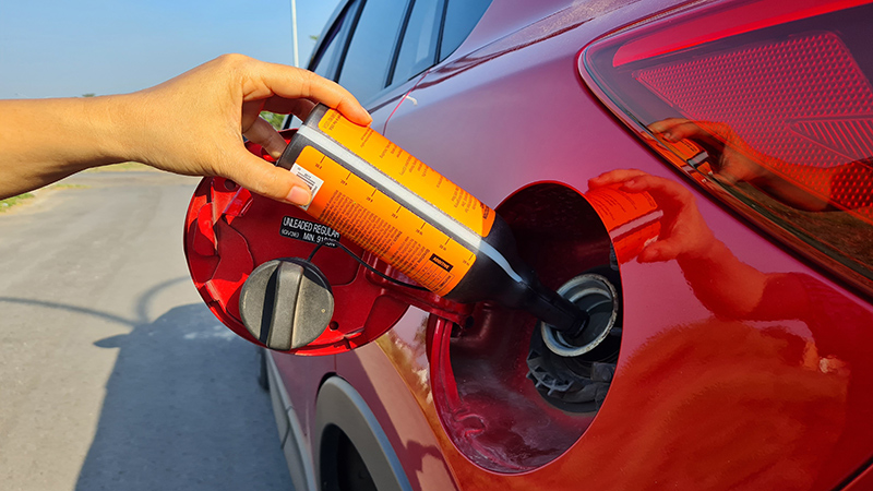 Aditivos para gasolina - vertiendo un aditivo en el depósito